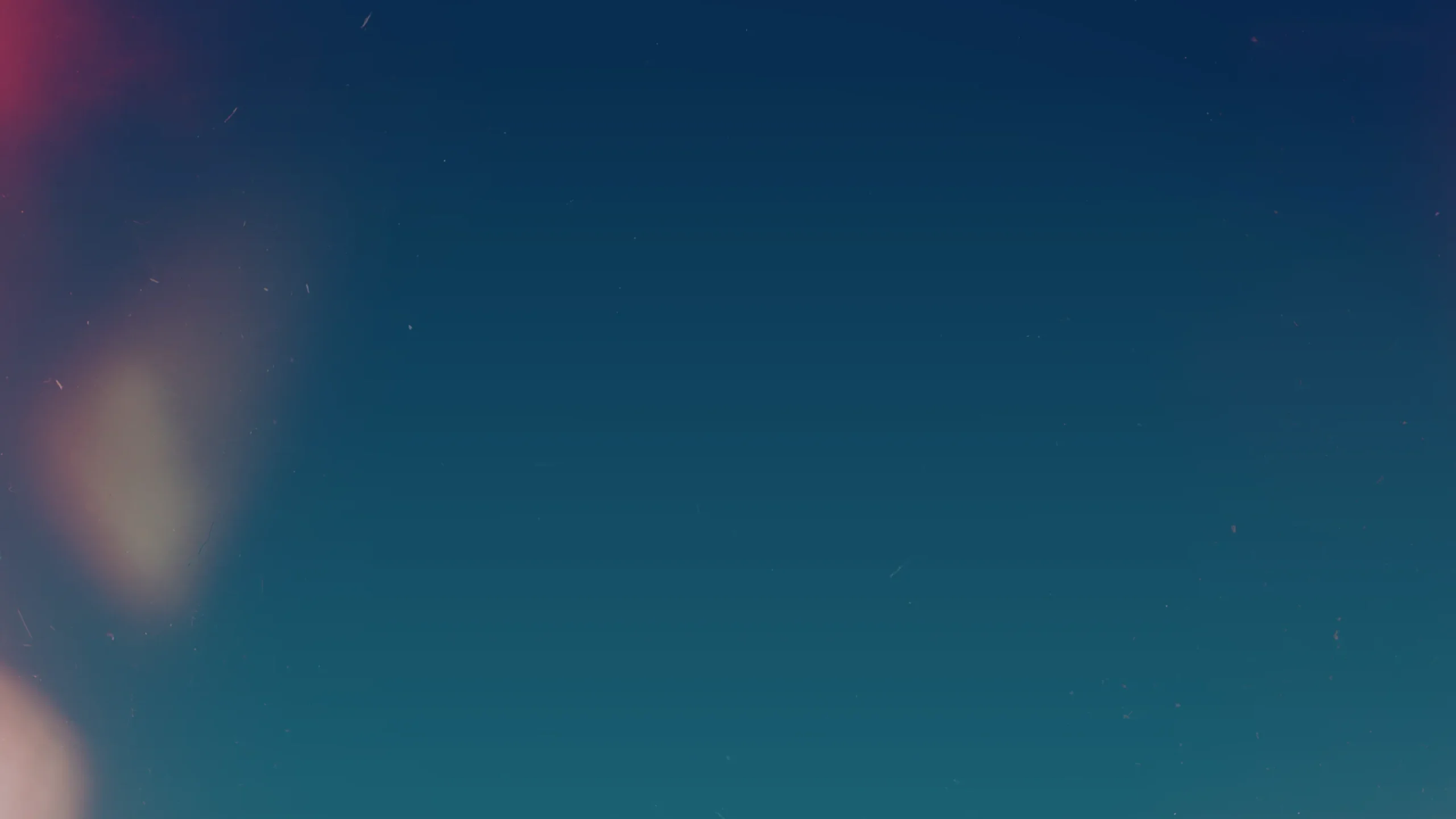 A gradient night sky with deep blue and teal tones fills most of the image. Faint stars are scattered, and soft, blurry light flares appear on the left side.