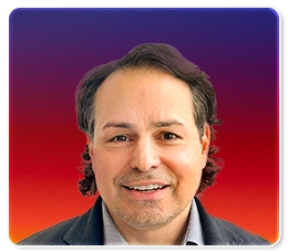 A man with dark, wavy hair and light skin, smiling, wearing a dark jacket and light shirt, is shown in front of a gradient background of dark blue at the top and red at the bottom.